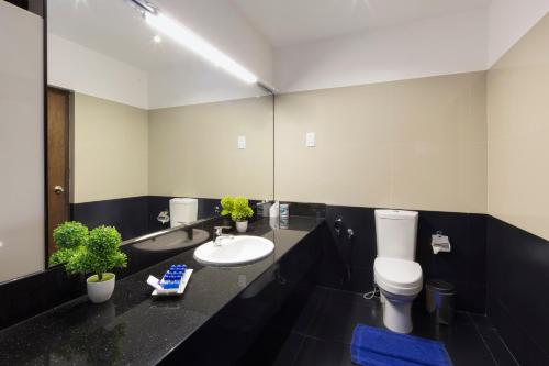 a bathroom with a sink and a toilet and a mirror at The Blue Wave Hotel in Arugam Bay