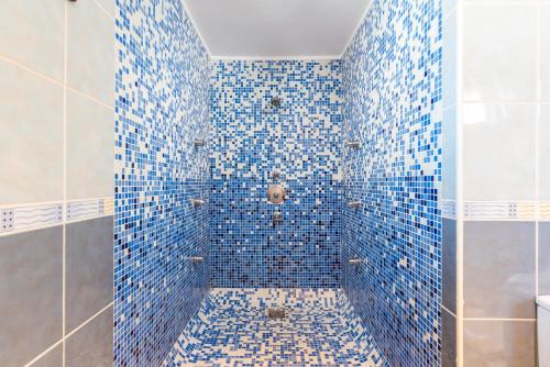 una doccia piastrellata blu con piastrelle blu sul muro di 2 CHARMING VILLA Private Pool and Sea View ad Adeje