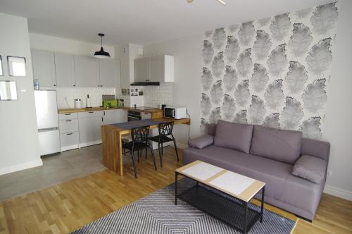 a living room with a purple couch and a kitchen at Apartament 5e in Szczecin