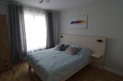 um quarto com uma cama e uma janela em Apartament 5e em Szczecin
