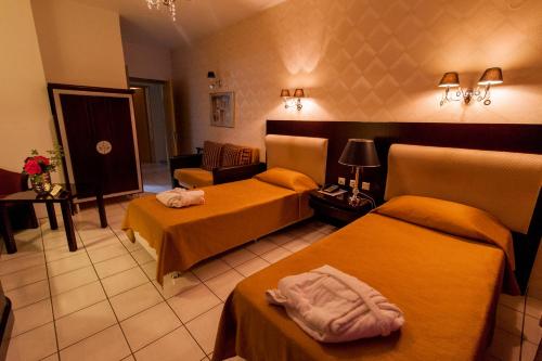 a hotel room with two beds and a couch at Krikonis Hotel in Ioannina