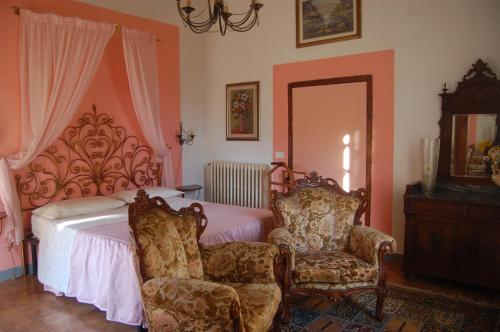a bedroom with a bed and two chairs at Fattoria Antognoni in Reggello