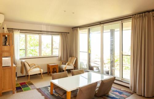 uma sala de estar com uma mesa, cadeiras e janelas em Yoichi-gun - House / Vacation STAY 43683 em Yoichi