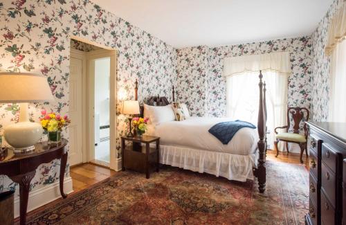 a bedroom with a bed and floral wallpaper at Jared Coffin House in Nantucket