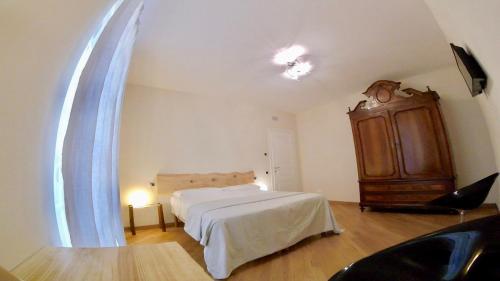 a bedroom with a bed and a dresser at LIBERTY ROOM AND BREAKFAST in Borgo Val di Taro