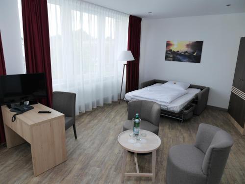 a hotel room with a bed and a living room at Ruhr Inn Hotel in Hattingen
