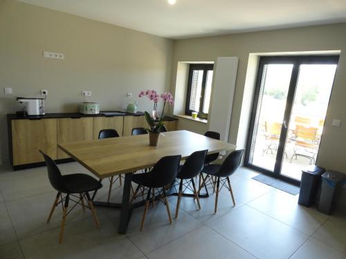 a dining room with a wooden table and chairs at Les violettes du Bugey in Marchamp