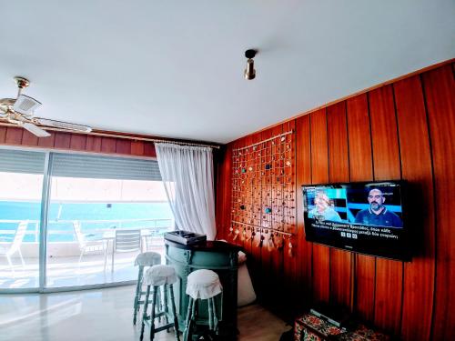 a living room with a tv on a wooden wall at Katerina's Maisonnette in Loutraki