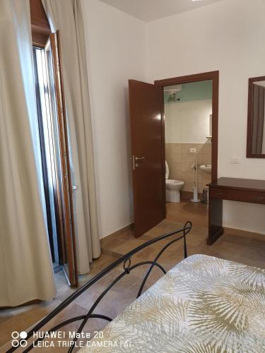 a bedroom with a bed and a bathroom with a toilet at Hotel-Locanda ZANZARINA D'ORO nel PARCO OGLIO SUD in Calvatone