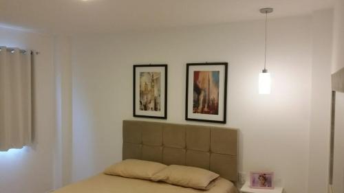普拉亞多海灘的住宿－AP. DE LUXO NO IBEROSTATE，卧室配有两张墙上的照片和一张床