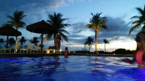 un bambino in piedi in una piscina in un resort di AP. DE LUXO NO IBEROSTATE a Praia do Forte