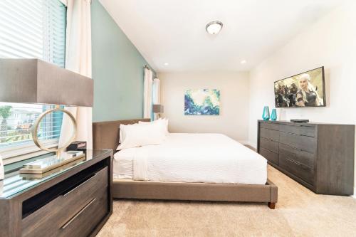 ein Schlafzimmer mit einem Bett, einer Kommode und einem Fenster in der Unterkunft Modern Home by Rentyl with Private Pool, Water Park and Resort Amenities - 301B in Orlando