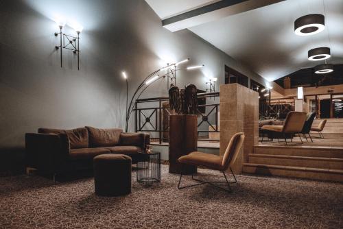 a living room with a couch and chairs and lights at Dwór w Tomaszowicach in Modlnica
