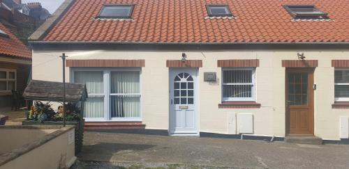 a small white house with a red roof at Swales cottage in Whitby