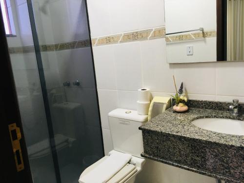 y baño con aseo, lavabo y ducha. en Hotel Faeli, en Matelândia