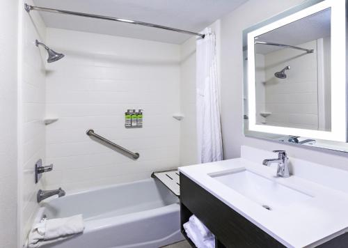 a bathroom with a sink and a tub and a mirror at Holiday Inn Express New Orleans East, an IHG Hotel in New Orleans