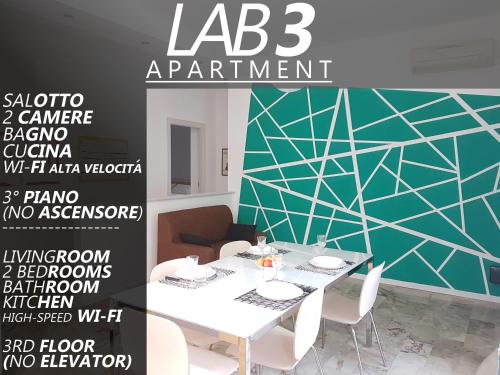 a dining room with a white table and a green wall at LAB3 City Private Apartment - 2 Bedrooms in Pavia