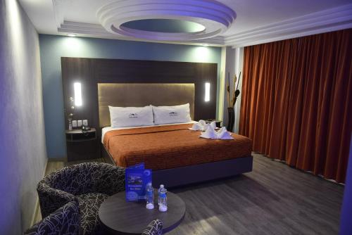 a hotel room with a bed and a chair and a table at Hotel Atizapan in Mexico City