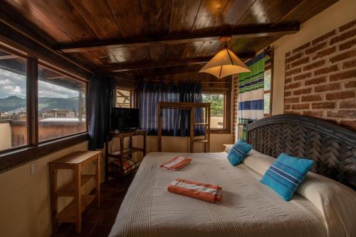 Un dormitorio con una cama con almohadas azules. en Yagil B&B en San Cristóbal de Las Casas