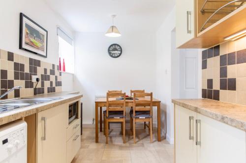 a kitchen with a table and a dining room at SunnyBank in Denby Dale