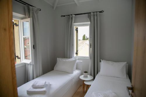 Habitación pequeña con 2 camas y 2 ventanas en Foxnest Rest Villa Corfu, en Kanálion