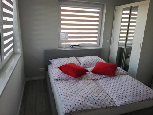 a bed with two red pillows in a bedroom at MARKAS in Rewa