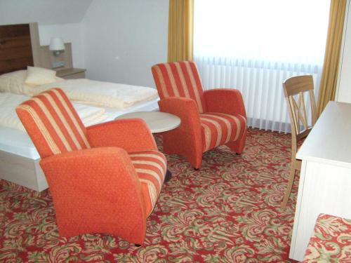a hotel room with chairs and a table and a bed at Landhotel Halbfas-Alterauge in Drolshagen