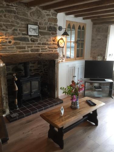 a living room with a table and a fireplace at Little Pinfold Cottage in Skipton
