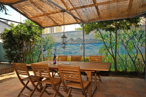 une table et des chaises en bois avec un tableau mural dans l'établissement The Secret Gem or The Hidden Gem or BOTH together, à Montreuil-Bellay