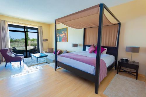 een slaapkamer met een hemelbed en een woonkamer bij Villa Estet Bağ Hotel in Kula