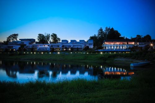 a night view of a resort and a lake at Słoneczny Cypel in Gródek Nad Dunajcem