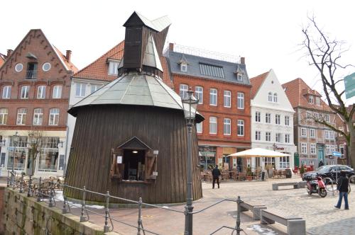 a small wooden building in a city with buildings at Hotel Am Fischmarkt in Stade
