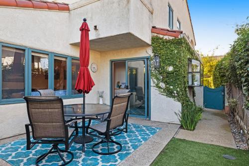 a patio with a table and chairs and an umbrella at Sunny's Santa Barbara Beach House in Santa Barbara