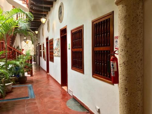 a hallway of a building with doors and plants at Casa Del Curato in Cartagena de Indias