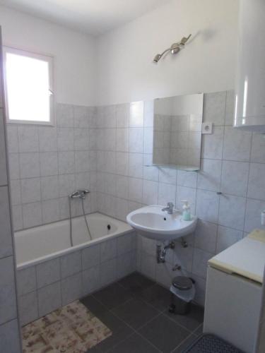 巴拉頓諾爾馬迪的住宿－Budatava nyaraló，浴室配有盥洗盆、浴缸和盥洗盆