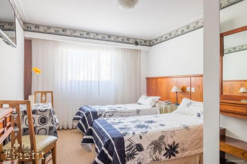 a hotel room with two beds and a piano at Hotel Bastit in Mar del Plata