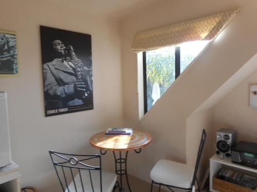 a room with a table and a picture of a man playing a saxophone at The Jazz Loft in Onetangi