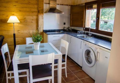 uma cozinha com uma mesa e uma máquina de lavar roupa em Lares · Cabañas Rurales em Las Médulas