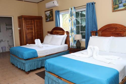 two beds in a room with blue and white at Brytan Villa in Treasure Beach