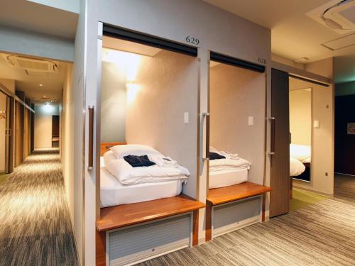 a room with two closets with beds at Gardens Cabin in Sapporo