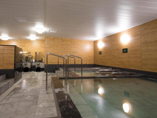 a large swimming pool in a building with a pool at Gardens Cabin in Sapporo