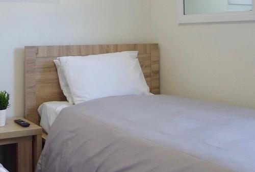 a bedroom with a white bedspread and pillows at Argyle Hotel Southern Highlands in Moss Vale