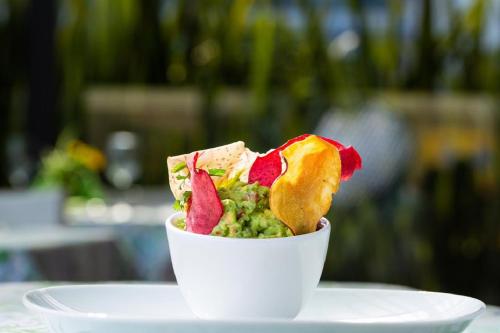 a bowl of guacamole on a white plate at Hotel Horizon & Convention Center in Morelia