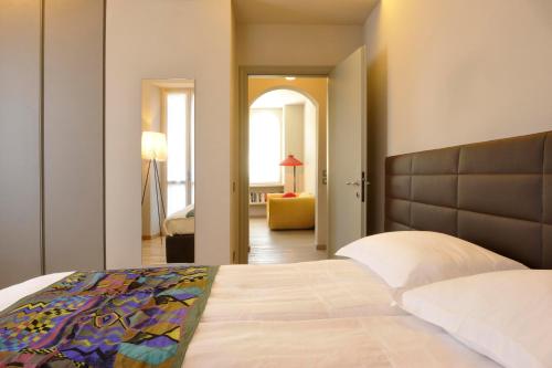 a bedroom with a bed and a living room at Sopra Il Posta in SantʼOmobono Imagna
