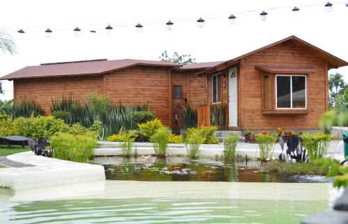 a house with a pond in front of it at Villarreal Lodge Hotel Ecológico in Totolapan