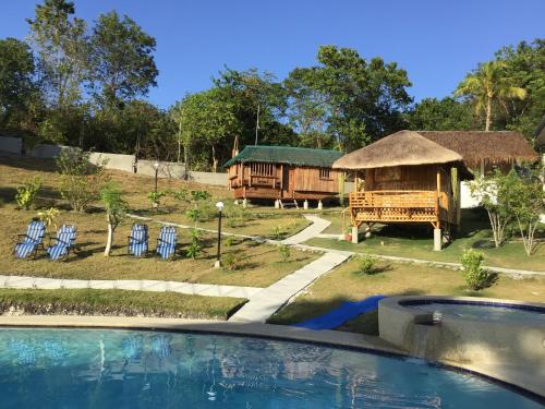 a resort with a swimming pool and a building at Cuestas Beach Resort and Restaurant in Badian