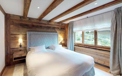 a bedroom with a large white bed and a window at Giant 7 in St. Moritz