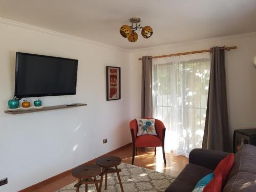 a living room with a couch and a tv on the wall at Apartamento La Calera in La Calera
