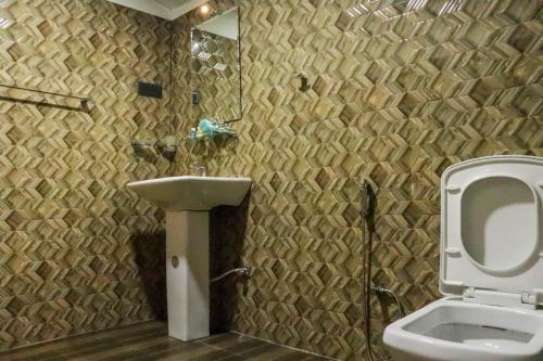 a bathroom with a sink and a toilet at Levona Garden Resort in Habarana