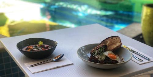 dos tazones de comida sentados en una mesa en Port Douglas Peninsula Boutique Hotel - Adults Only Haven, en Port Douglas